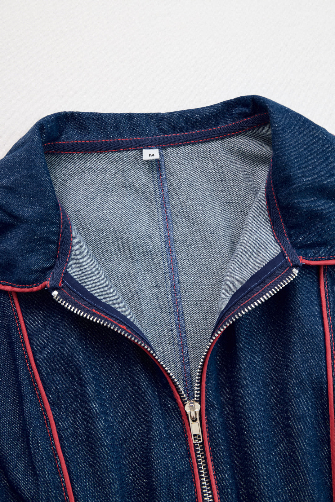 Close-up of stand collar and double zip with red topstitching