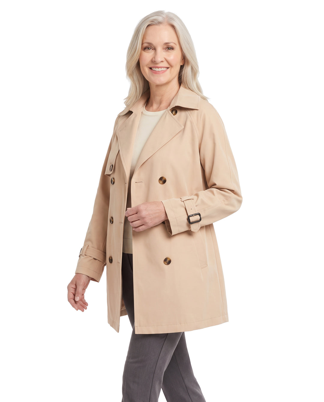 Woman wearing the khaki beige belted trench coat, three quarter walking pose
