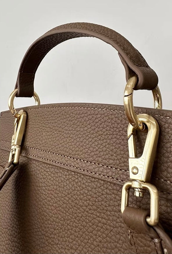 Leather satchel bag side profile showing structured shape