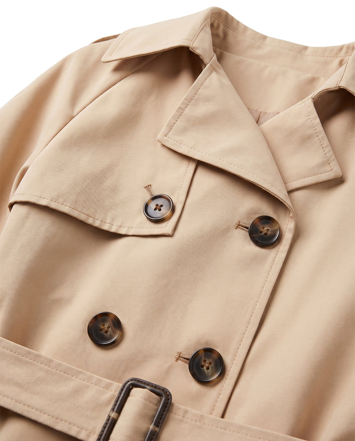 Close up of the storm flap, button rows and belt buckle on the trench coat