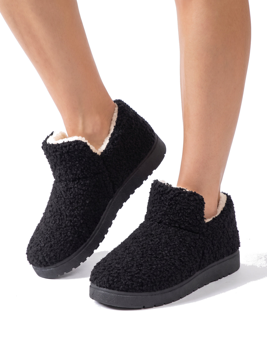 Woman wearing black fleece-lined ankle slipper boots