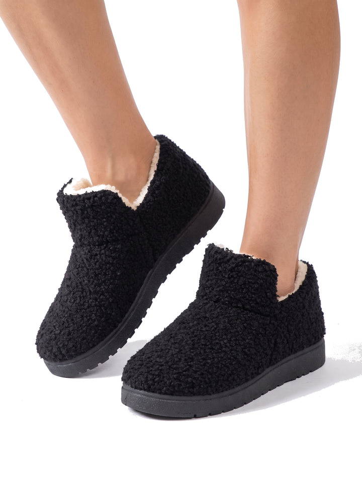 Woman wearing black fleece-lined ankle slipper boots